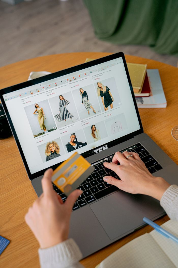 Mastering the First Impression: Your intriguing post title goes here A woman makes an online purchase using a credit card on her laptop, browsing an online fashion store.